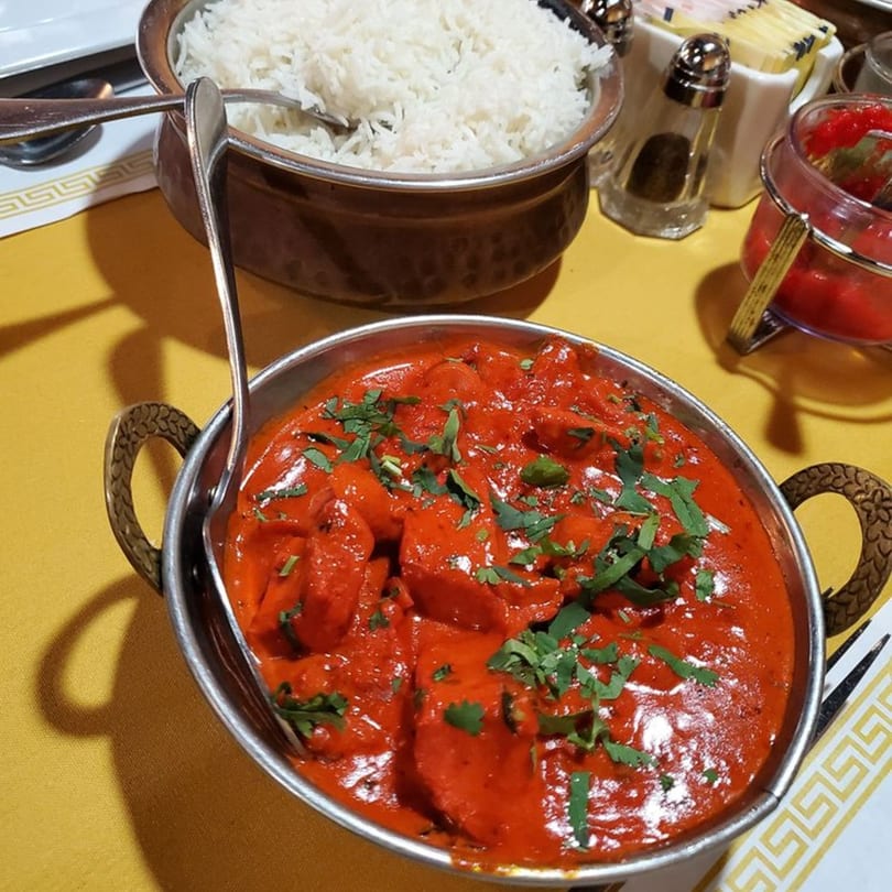 Flavor Of India's chicken tikka masala, garnished with cilantro, served with rice and chutney.